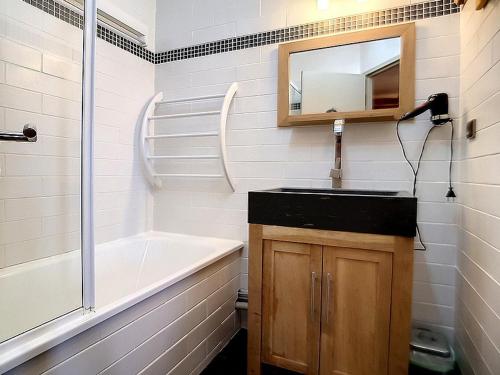 une salle de bain avec un lavabo, une baignoire et un miroir dans l'établissement Studio rénové aux Menuires, départ skis aux pieds - FR-1-344-840, aux Menuires