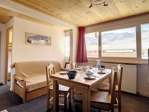 une salle à manger avec une table et des chaises et une fenêtre dans l'établissement Appartement rénové · Départ et retour ski aux pieds · 6 pers · Quartier La Croisette - FR-1-344-847, aux Menuires