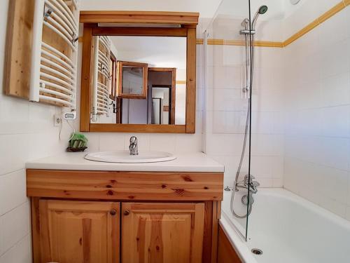 uma casa de banho com um lavatório, um espelho e uma banheira em Appartement Les Menuires, 3 pièces, 6 personnes - FR-1-344-849 em Levassaix