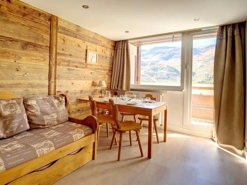 - une salle à manger avec une table, une table et un canapé dans l'établissement Appartement duplex confortable Au pied des pistes Balcon - FR-1-344-853, aux Menuires