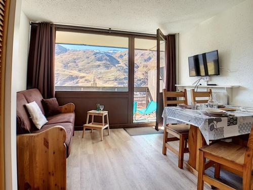 - un salon avec une table et une vue sur la montagne dans l'établissement Studio rénové · Ski-in/Ski-out · Balcon sud · 4 pers · Proche ESF - FR-1-344-874, aux Menuires