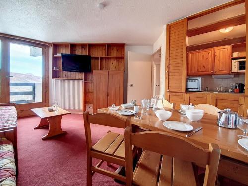 une salle à manger avec une table en bois et une cuisine dans l'établissement Appartement cosy, 2 pièces, 5 pers., piste à pied, balcon ouest, La Croisette, Les Belleville - FR-1-344-878, aux Menuires