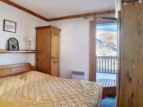 une chambre avec un lit et une porte coulissante en verre dans l'établissement Appartement spacieux, ski aux pieds, terrasse ensoleillée et parking privé - FR-1-344-886, aux Menuires