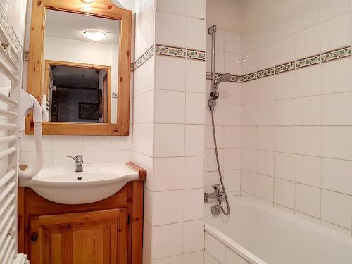 une salle de bain avec un lavabo, un miroir et une baignoire dans l'établissement Appartement spacieux, ski aux pieds, terrasse ensoleillée et parking privé - FR-1-344-886, aux Menuires