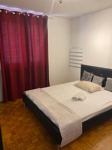 uma cama num quarto com cortinas vermelhas em Lovely apartment with fabulous view em Koper