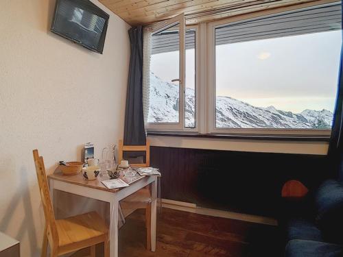 une salle à manger avec une table et une grande fenêtre dans l'établissement Studio 13m² pour 2 pers. - Pied des pistes et Centre station - 2 Flocons Argent - FR-1-344-876, aux Menuires