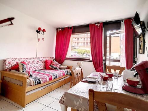 un salon avec un canapé et une table dans l'établissement Studio Cabine Confort · Proche Pistes · Balcon Sud - FR-1-344-903, aux Menuires