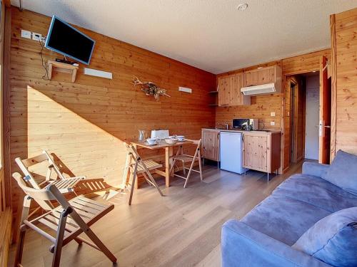 un salon avec un canapé et une table et une cuisine dans l'établissement Studio rénové · Ski aux pieds · Balcon - FR-1-344-890, aux Menuires