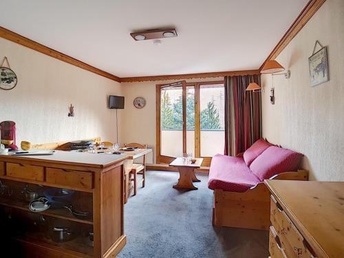 Cette chambre dispose d'une cuisine avec une table et un canapé. dans l'établissement Appartement skis aux pieds avec balcon exposé sud, 2 pièces, 4 pers., quartier animé des Bruyères - FR-1-344-904, aux Bruyères