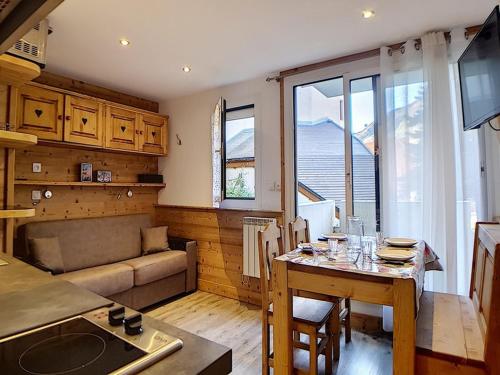 une cuisine et un salon avec une table et un canapé dans l'établissement Studio rénové proche pistes avec balcon, 4 pers, WIFI - FR-1-344-909, aux Menuires