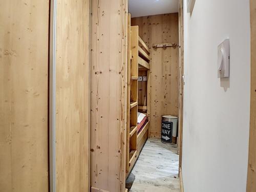 Cette chambre dispose de murs en bois et d'un couloir avec des étagères en bois. dans l'établissement Studio rénové proche pistes avec balcon, 4 pers, WIFI - FR-1-344-909, aux Menuires