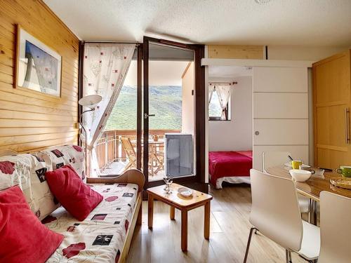 un salon avec un canapé et une table dans l'établissement Appartement lumineux Départ ski aux pieds Terrasse - FR-1-344-912, aux Menuires