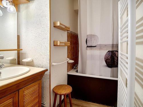 La salle de bains est pourvue d'un lavabo, d'une douche et d'un tabouret. dans l'établissement Appartement lumineux Départ ski aux pieds Terrasse - FR-1-344-912, aux Menuires