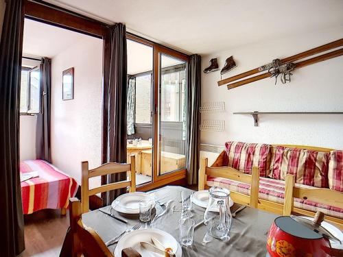 un salon avec une table et un canapé dans l'établissement Appartement cosy 4 pers, ski aux pieds, balcon Sud-Ouest - FR-1-344-919, aux Menuires