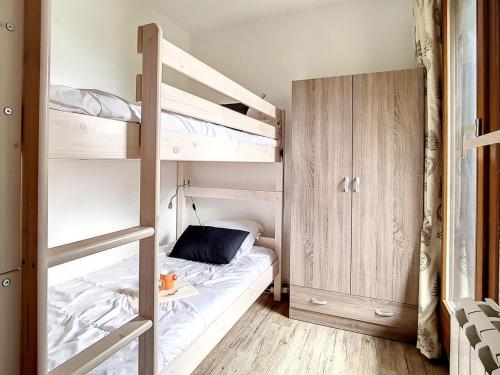 - une chambre avec des lits superposés et une échelle menant à un lit superposé dans l'établissement Appartement confortable Proche des pistes Balcon Casier à skis - FR-1-344-916, aux Menuires