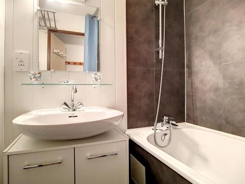 une salle de bain avec un lavabo et une baignoire dans l'établissement Appartement confortable Proche des pistes Balcon Casier à skis - FR-1-344-916, aux Menuires