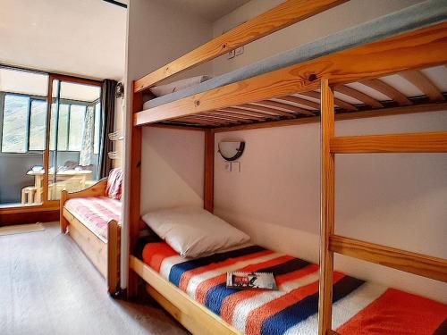 une chambre avec deux lits superposés et une fenêtre dans l'établissement Appartement cosy 4 pers, ski aux pieds, balcon Sud-Ouest - FR-1-344-919, aux Menuires