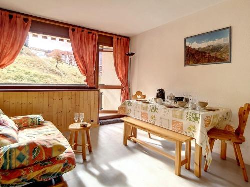 un salon avec une table et un canapé dans l'établissement Studio lumineux avec accès direct aux pistes et balcon - FR-1-344-917, aux Menuires