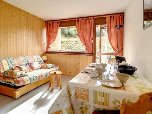 un salon avec un canapé et une table dans l'établissement Studio lumineux avec accès direct aux pistes et balcon - FR-1-344-917, aux Menuires