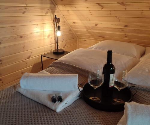 een slaapkamer met 2 bedden, wijnglazen en handdoeken bij Sauna balia - Nowa Osada Domki przy plaży - całoroczne domki na Mazurach in Ryn