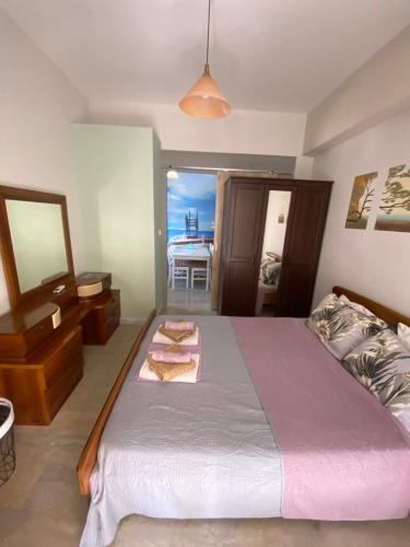 a bedroom with a large bed and a table at Maki Apartment in Paralia Katerinis