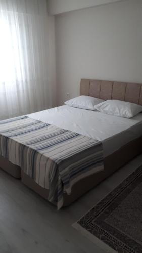 a bedroom with a large bed with white sheets and pillows at Geyikli suit apart3 in Geyikli