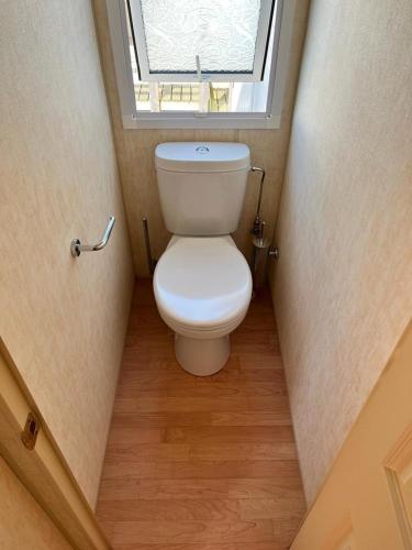 a toilet in a small bathroom with a window at Stacaravan Middelkerke in Middelkerke