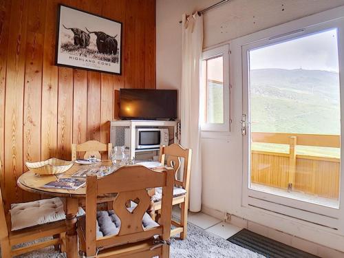 une salle à manger avec une table et un micro-ondes et une fenêtre dans l'établissement Studio Mezzanine, Accès Direct aux Pistes, Balcon, Capacité 4 pers - FR-1-344-835, aux Menuires