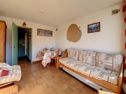 un salon avec un canapé et une table dans l'établissement Studio lumineux Ski aux pieds Balcon - FR-1-344-931, aux Menuires