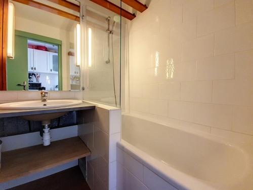 une salle de bain avec un lavabo et une baignoire dans l'établissement Studio lumineux Ski aux pieds Balcon - FR-1-344-931, aux Menuires
