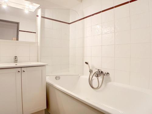 a white bathroom with a tub and a sink at Studio rénové proche pistes avec balcon, 3 couchages - FR-1-344-948 in Les Menuires