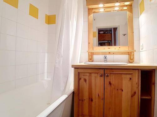 une salle de bain avec un lavabo, un miroir et une baignoire dans l'établissement Studio 3 pers, ski aux pieds, balcon nord, TV, cuisine équipée, accès galerie marchande - FR-1-344-966, aux Menuires