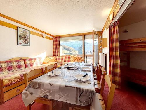 une salle à manger avec une table et un canapé dans l'établissement Studio lumineux avec accès direct aux pistes, balcon sud et proche des commodités - FR-1-344-959, aux Menuires