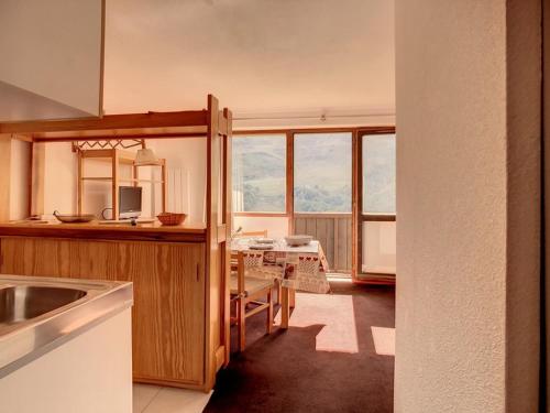 - une cuisine avec une table et une vue sur les montagnes dans l'établissement Studio lumineux avec balcon - Départ skis aux pieds - 4 pers, TV, DVD, proche commodités - FR-1-344-967, aux Menuires