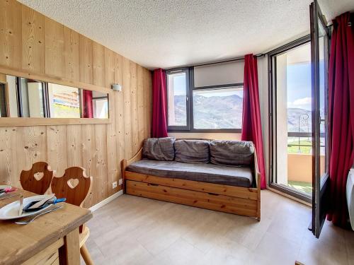 une chambre avec un banc devant une fenêtre dans l'établissement Charmant appartement rénové à Reberty 1850, proche pistes, balcon, animaux acceptés - FR-1-344-969, aux Menuires