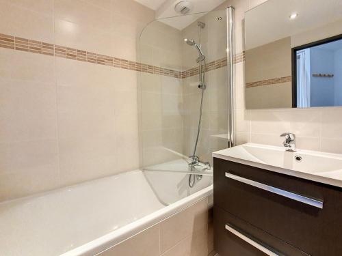uma casa de banho com uma banheira branca, um lavatório e uma banheira tubermottermottermott em Appartement Les Menuires, 2 pièces, 4 personnes - FR-1-344-969 em Les Menuires