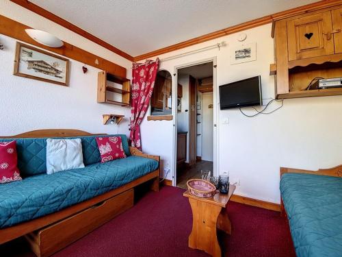 un salon avec un canapé bleu et une télévision dans l'établissement Studio agréable Au pieds des pistes Balcon nord - FR-1-344-995, aux Menuires