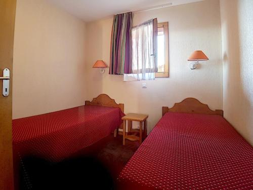 - une chambre avec 2 lits rouges et une fenêtre dans l'établissement Charmant 2 pièces avec balcon exposé Sud, départ ski aux pieds, au cœur des Bruyères - FR-1-344-998, aux Bruyères