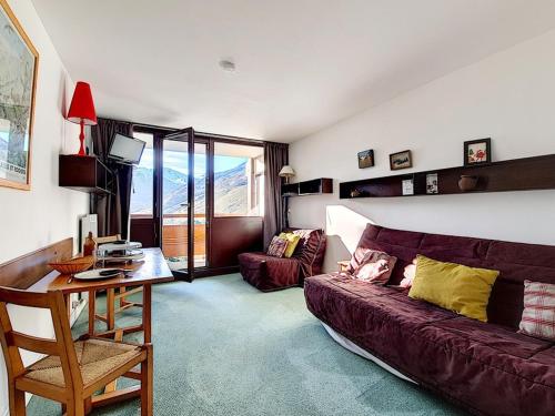 un salon avec un canapé et une table dans l'établissement Studio fonctionnel au pied des pistes avec balcon - FR-1-344-989, aux Menuires