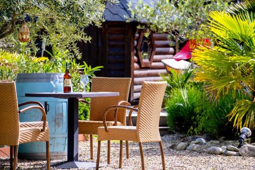 a patio with a table and chairs in a garden at Le Bassin du Tertre in Fronsac