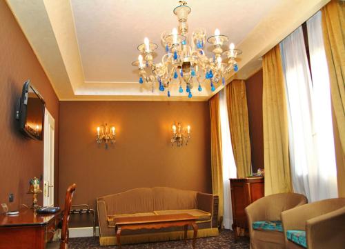 a living room with a chandelier and a couch at Pesaro Palace in Venice