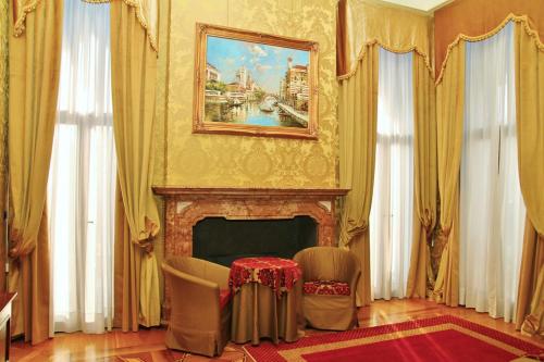 a living room with a fireplace and a painting on the wall at Pesaro Palace in Venice