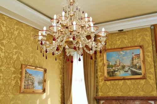 a chandelier in a room with paintings on the walls at Pesaro Palace in Venice