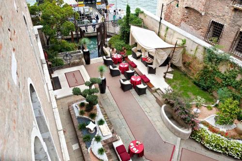 a restaurant with tables, chairs, tables and umbrellas at Pesaro Palace in Venice