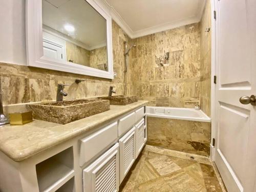 a bathroom with two sinks and a bath tub at Stylish Lux Beach Condo Aquamarina Cap Cana in Punta Cana