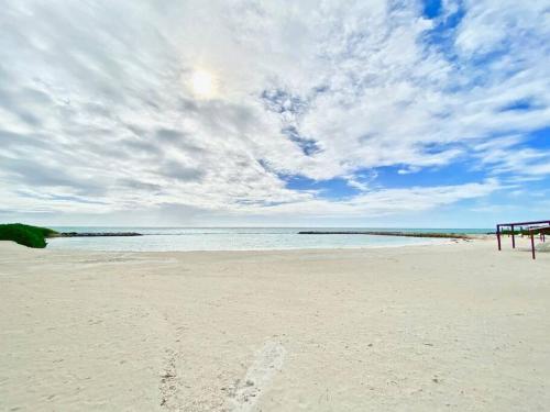 a beach with a cloudy sky and the ocean at Stylish Lux Beach Condo Aquamarina Cap Cana in Punta Cana