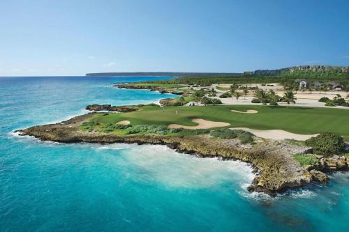 an aerial view of a golf course on the ocean at Stylish Lux Beach Condo Aquamarina Cap Cana in Punta Cana