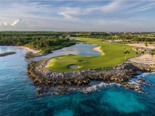 an aerial view of a golf course and the ocean at Stylish Lux Beach Condo Aquamarina Cap Cana in Punta Cana