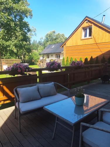 a couch and a coffee table on a deck at Gościnna Chata in Jaworki