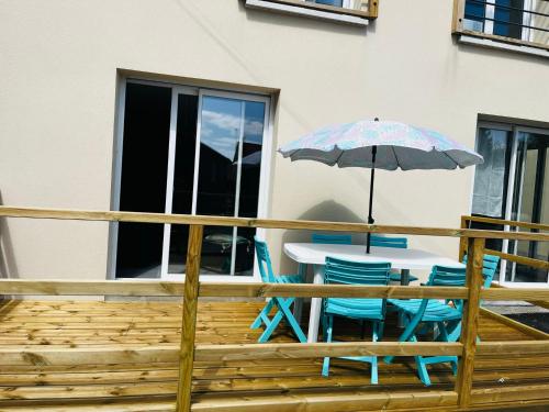 une table et des chaises avec un parasol sur une terrasse dans l'établissement La maison des hirondelles, à Berck-sur-Mer
